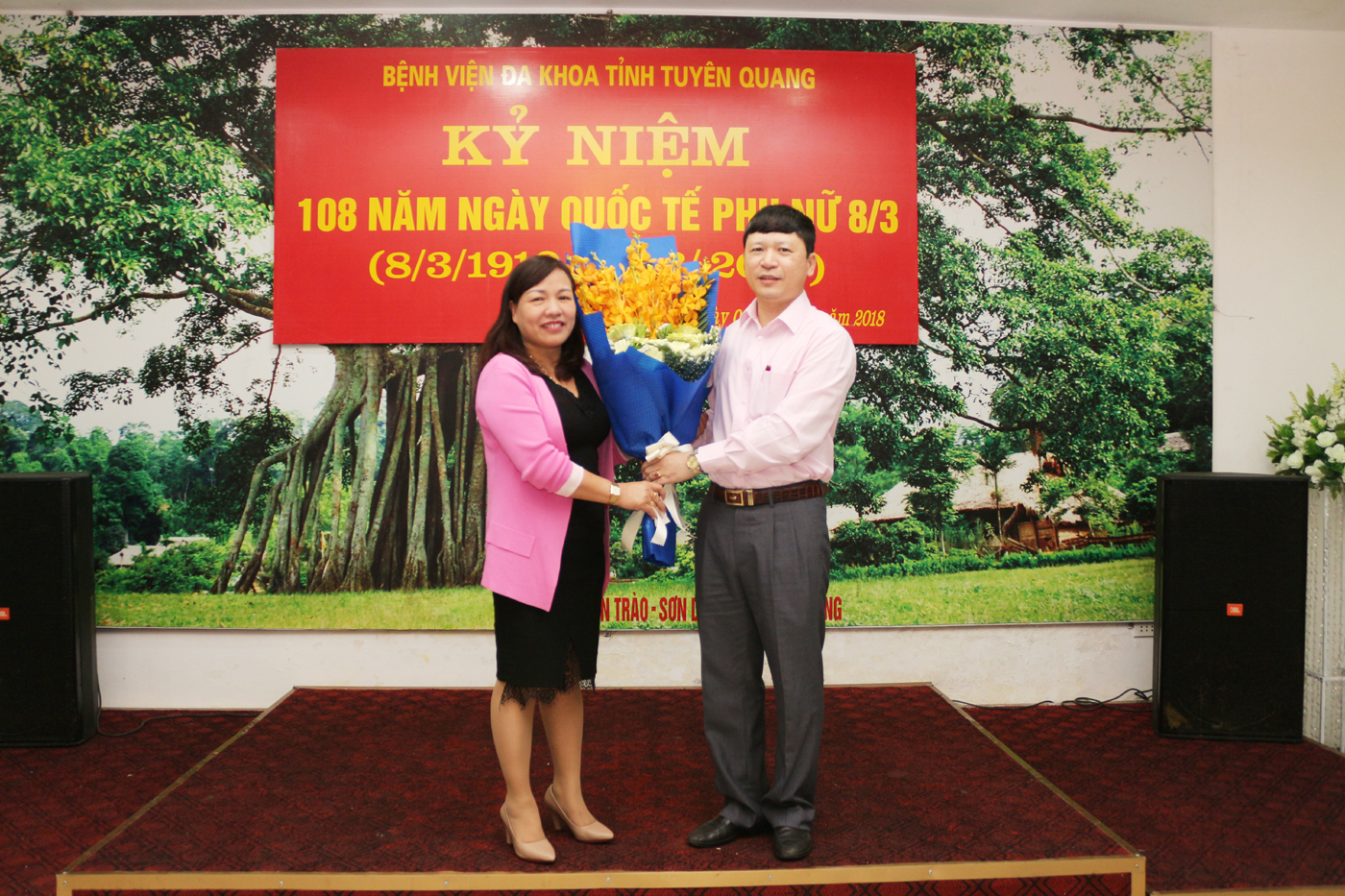 Đ/c Phạm Quang Thanh tặng hoa cho đ/c Phạm Thị Thanh Bình, Phó Chủ tịch Công đoàn Bệnh viện - Đại diện cho các nữ cán bộ tham dự buổi gặp mặt